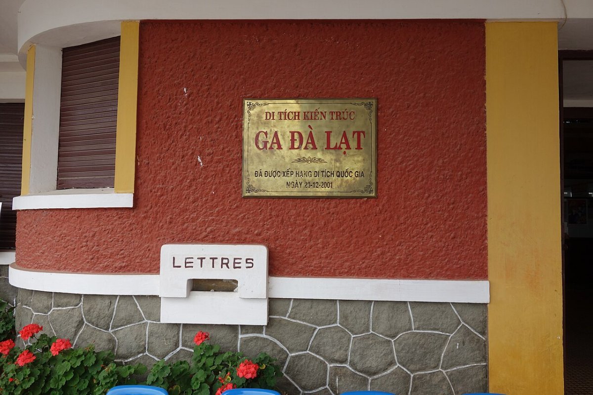 Name plaque on the yellow and red wall of Da Lat Railway Station