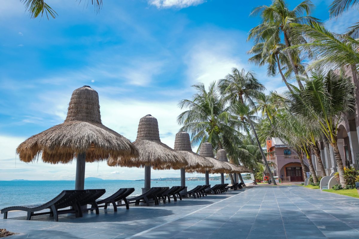 Private beach with thatched umbrellas at Le Viva Resort Mui Ne
