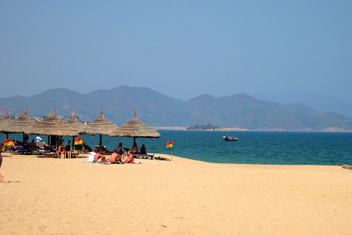 Halal Restaurants in Nha Trang 2026: 7 Verified Places by Area, from the Tourist Quarter to the Cham Kitchen Thatched umbrellas on Nha Trang beach facing the bay and islands
